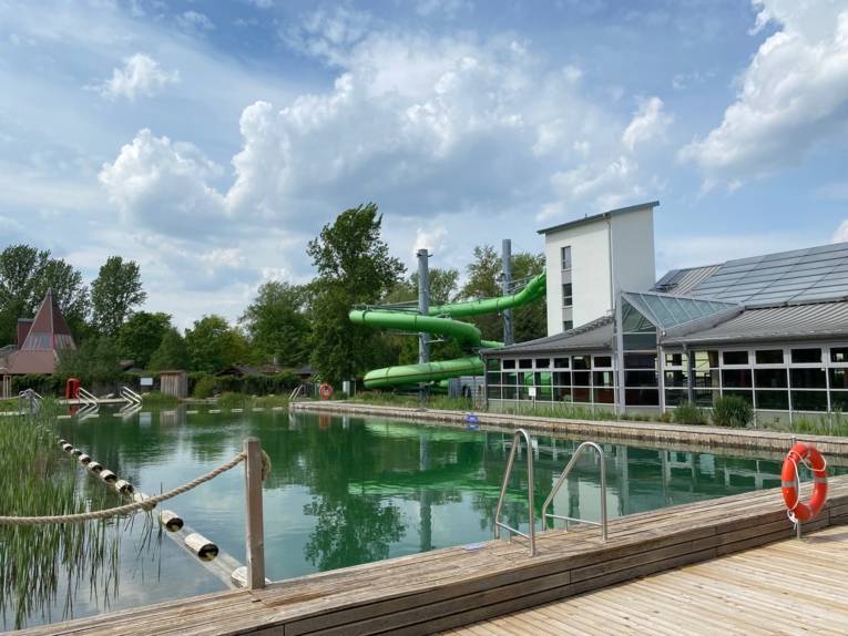 Badesee, im Hintergrund eine Rutsche und das Hallenbad