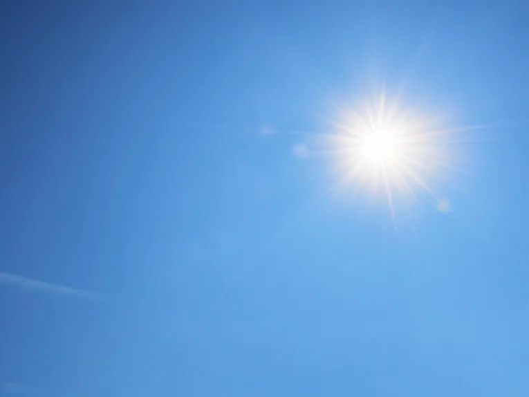 Eine gleißend hell strahlende Sonne auf blauem Himmel