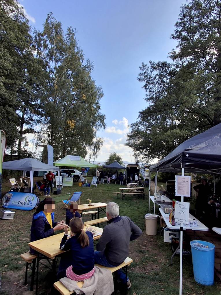 Blick &uuml;ber einen Rastplatz zum Steinhuder Meer, Zelte und St&auml;nde empfangen G&auml;ste.