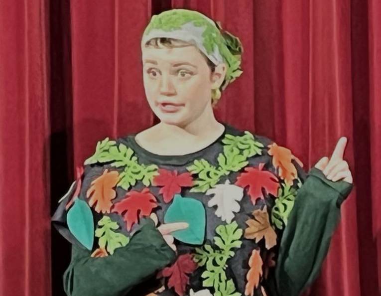 Frau mit Kopftuch in Shirt mit applizierten bunten Blättern.