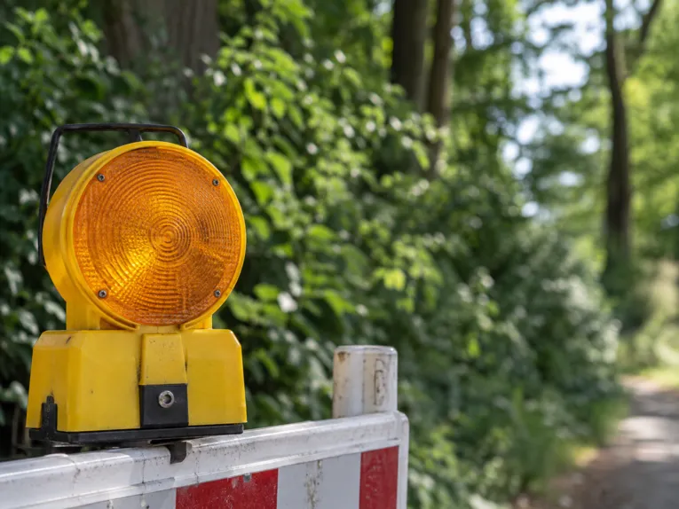 Eine Absperrung an einem begrünten Wegestück.