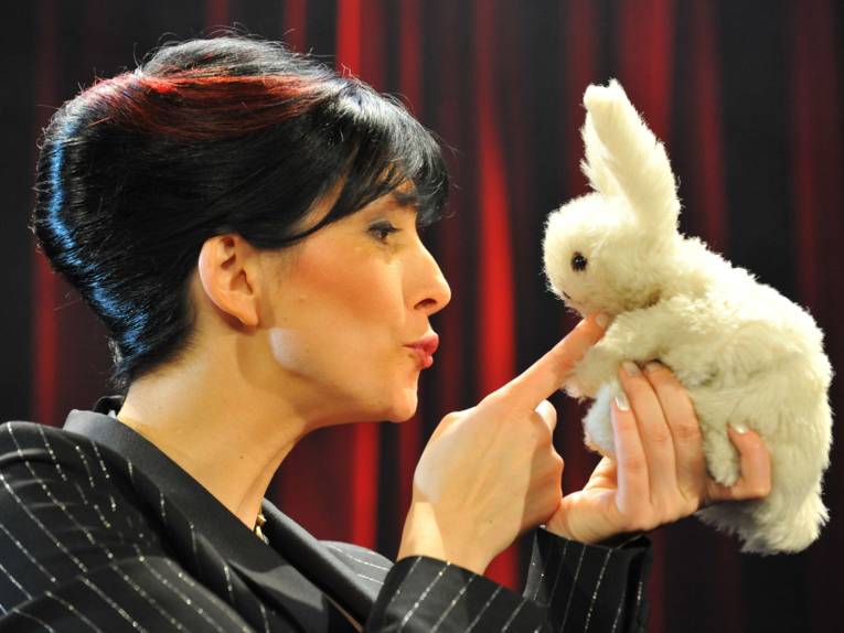 Profilbild einer Frau mit Dutt und einem Plüschhasen in den Händen