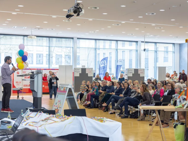 Ein Mann auf einer B&uuml;hne vor Publikum.
