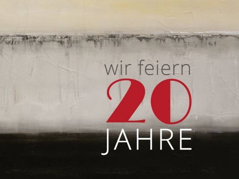Zu sehen ein abstrakt-neutraler Hintergrund mit der Aufschrift: „wir feiern 20 Jahre“