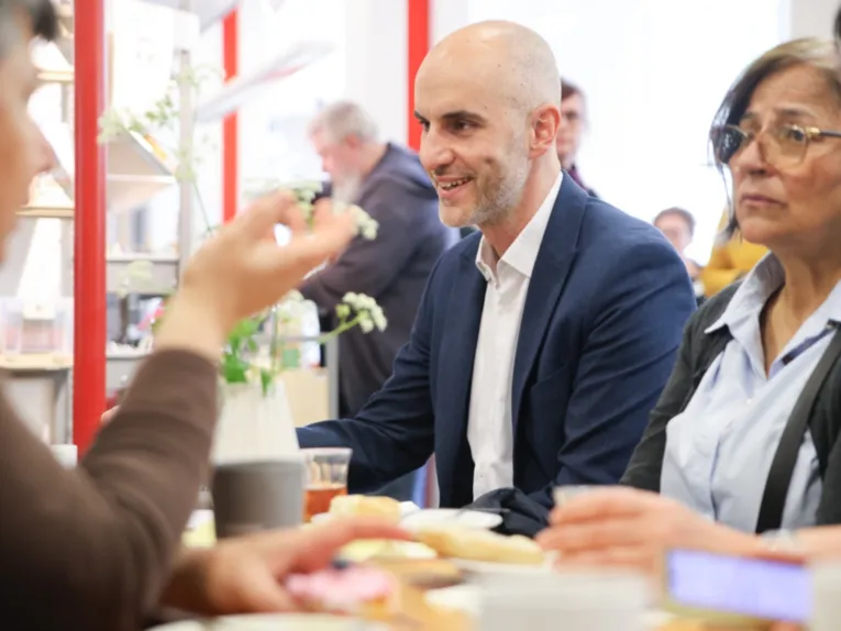 Vier Menschen sitzen an einem Tisch und sprechen miteinander.