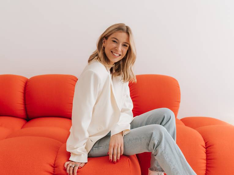 Eine junge Frau sitzt auf einem Sofa