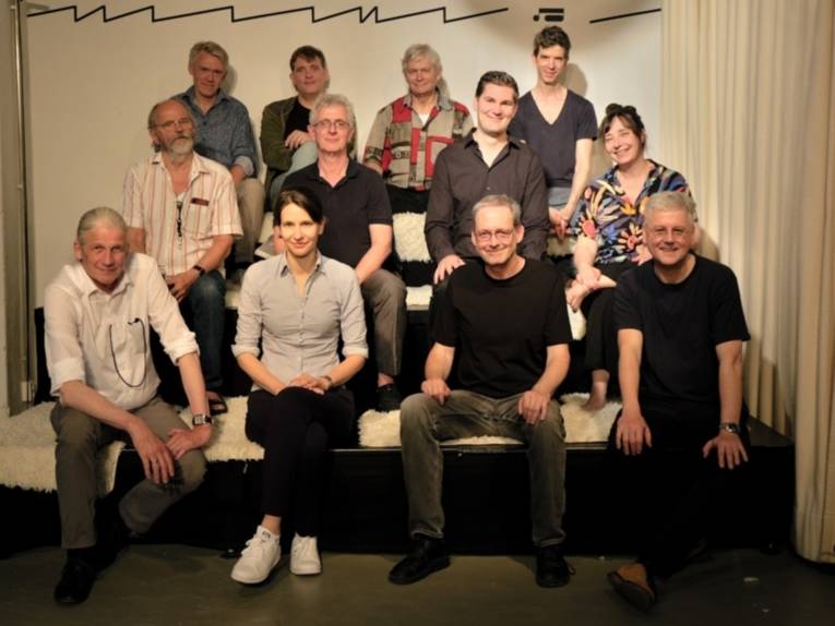 Auf dem Bild ist eine Gruppe von Menschen zu sehen, die in die Kamera schaut.