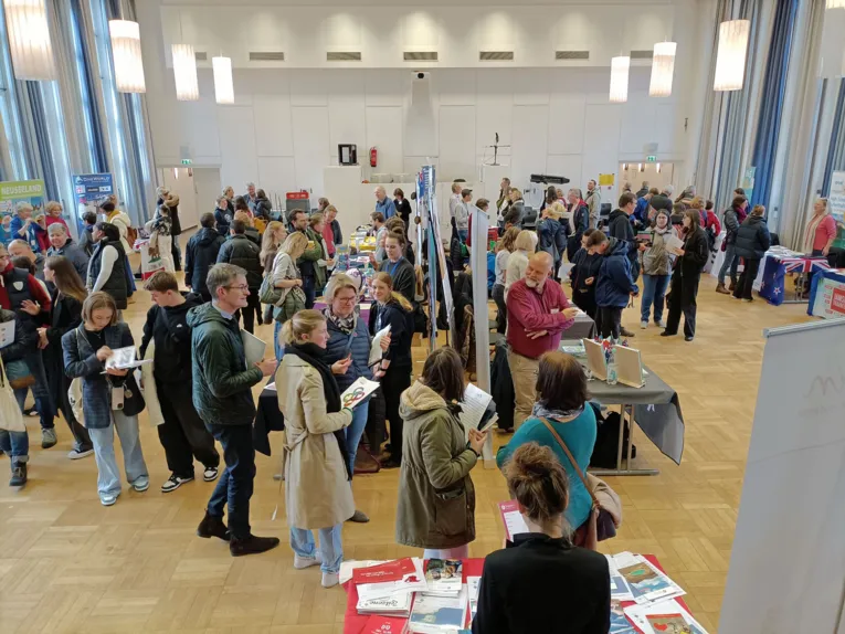 Junge Erwachsene um Informationsstände verteilt.