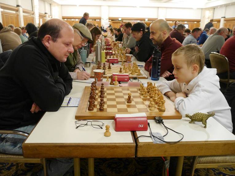 Mehrere Tischreihen mit Schachspielenden