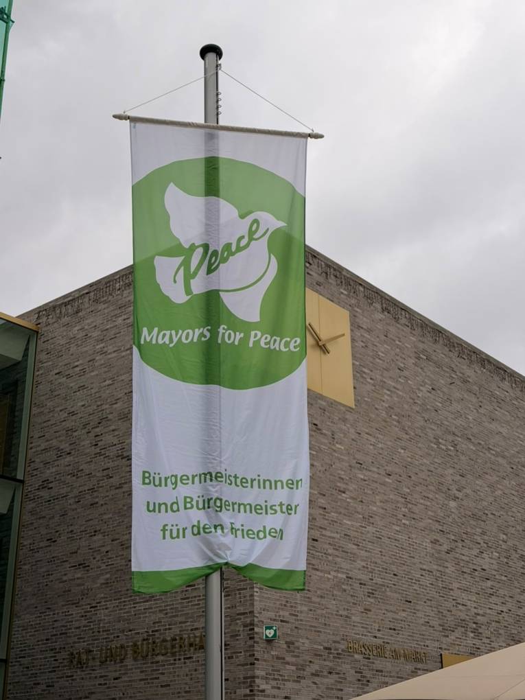 Die Mayors for Peace Flagge weht vor dem Rat- und Bürgerhaus in Holzwickede.
