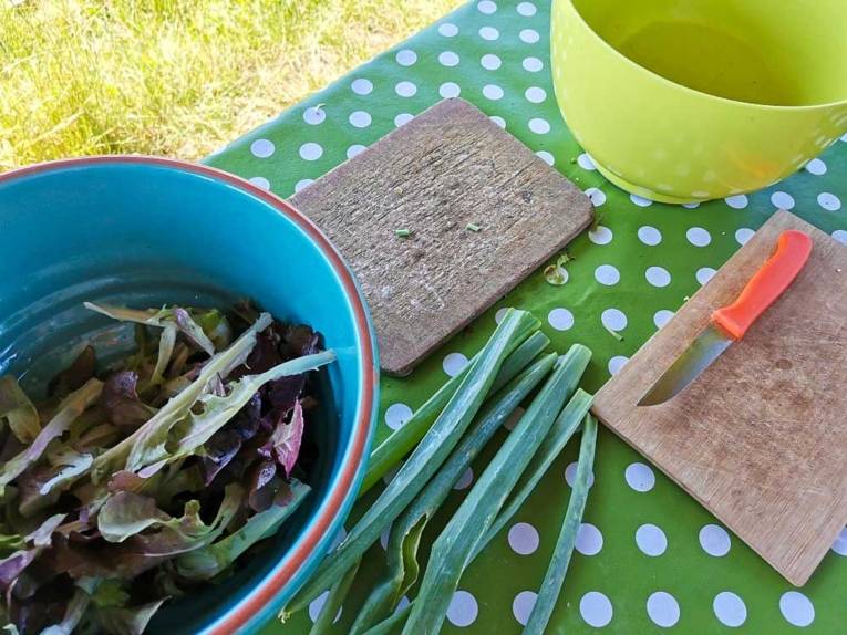 Ein Tisch mit Salat und Schneidebrettern.