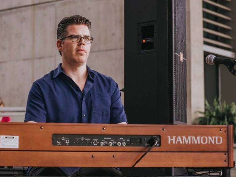 Mann mit kurzem Haar und Brille hinter einer Hammond-Orgel