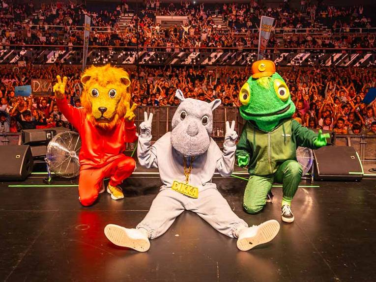 Drei Personen in einem Löwen-, Nashorn- und Chamäleonkostüm