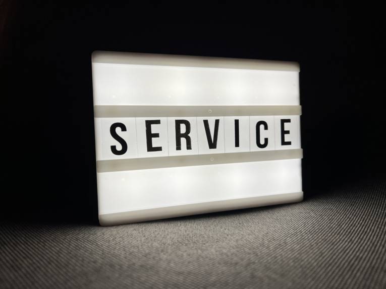 Auf einer Leuchtbox steht das Wort Service.