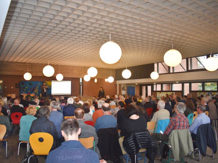 Ein Publikum schaut auf ein Podium.