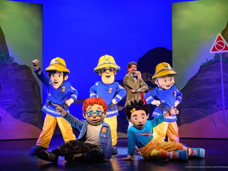 Zu sehen sind lebensgroße Puppen der Charaktere aus der Kindershow „Feuerwehrmann Sam" auf einer Bühne.