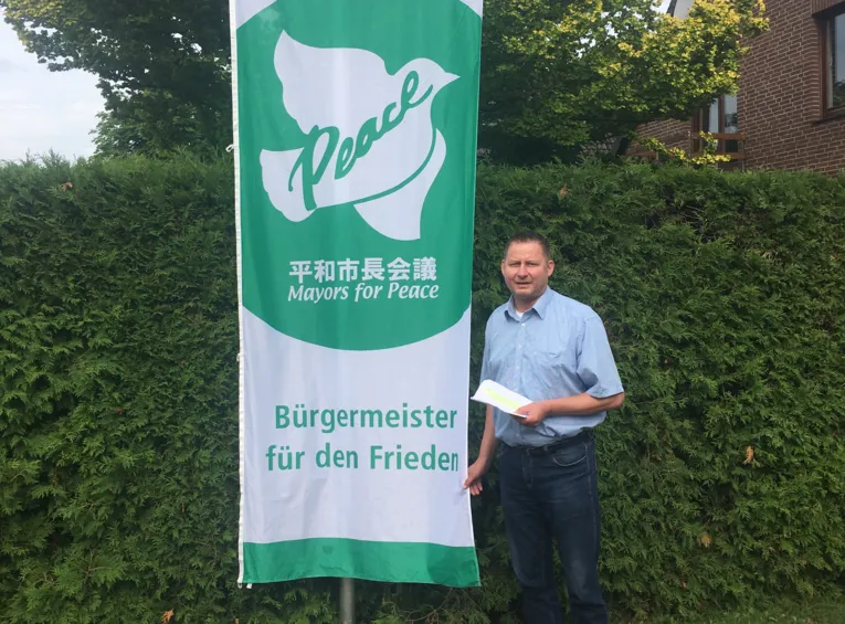 B&uuml;rgermeister Clemens Leder hisst die Mayors for Peace Flagge in Wendisch-Evern