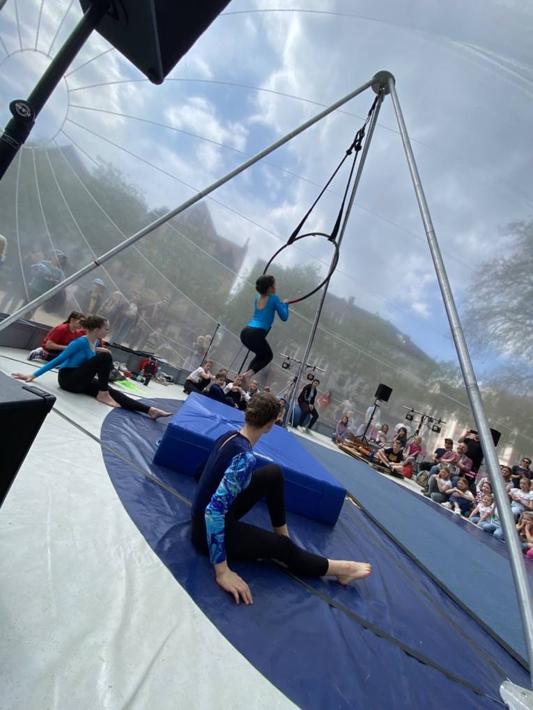 Ein Mädchen macht artistische Übungen an einem Reifen.