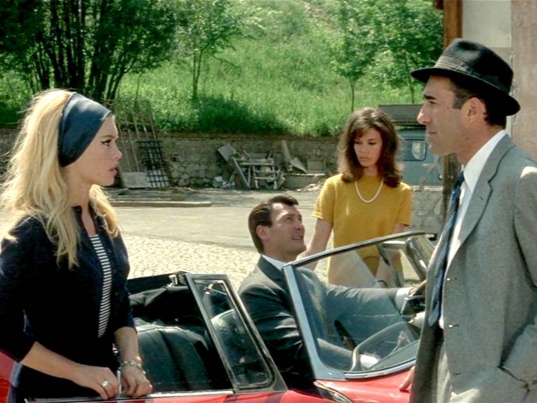 Vier Personen und ein rotes Auto.