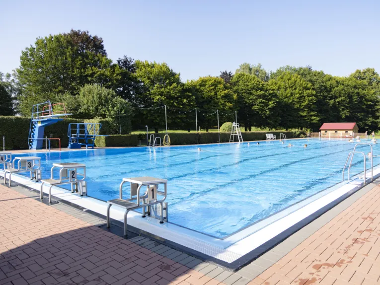 Schwimmbecken mit Schwimmern bei Sonnenschein