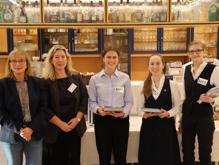 Fünf Personen, drei davon halten ein Buch in der Hand