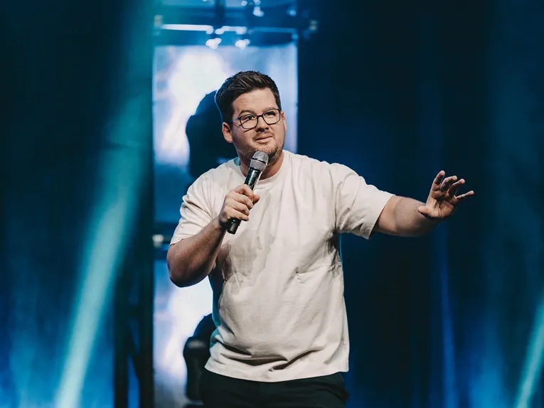 Comedian Chris Tall mit Mikrofon auf der Bühne