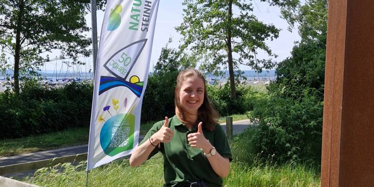 Portr&auml;tfoto einer Frau mit dem Steinhuder Meer im Hintergrund, sie reckt beide Daumen nach oben.