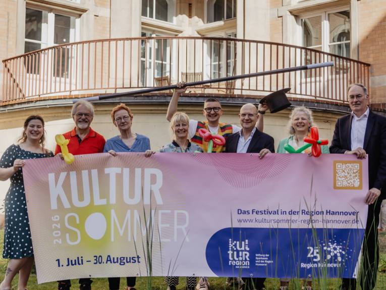 Acht Personen halten gemeinsam ein Banner: Kultursommer 2026