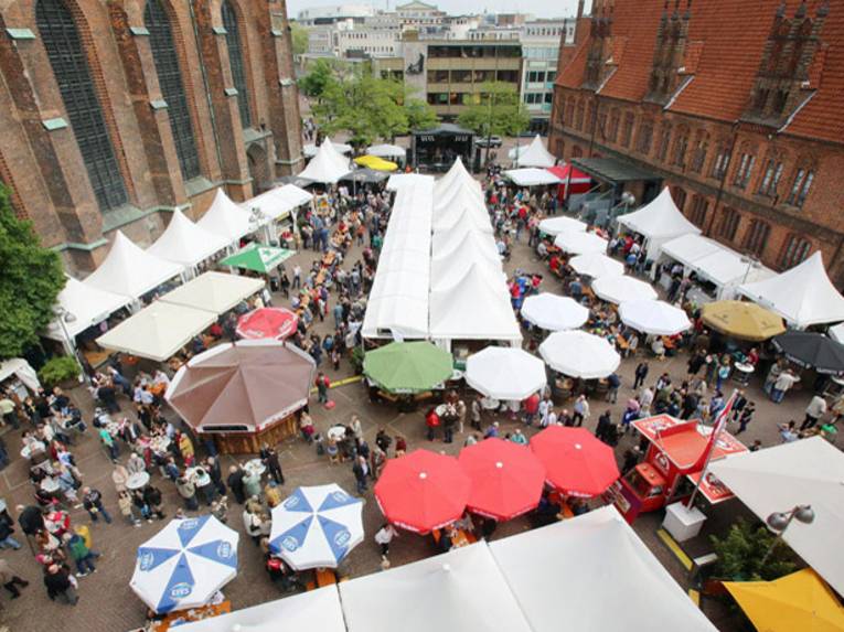 Blick von oben auf einen Marktplatz mit überdachten Ständen.