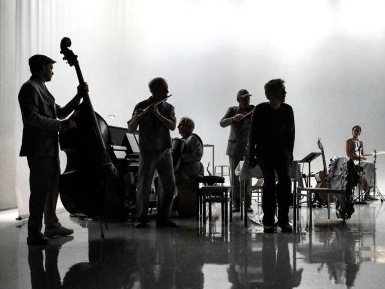 Band im Schatten auf einer Bühne.