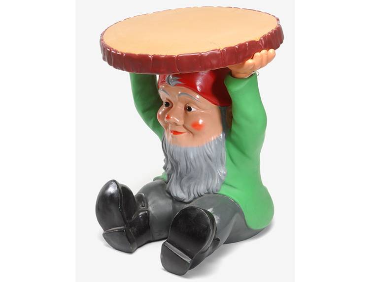 Hocker „Attila“, Entwurf: Philippe Starck, 1999, Hersteller: Kartell, sitzender "Zwerg" mit Bart, roter Mütze, grüner Jacke, grauer Hose und schwarzen Stiefeln, Beine nach vorne gestreckt und eine Baumscheibe über den Kopf haltend
Foto: Christian Tepper