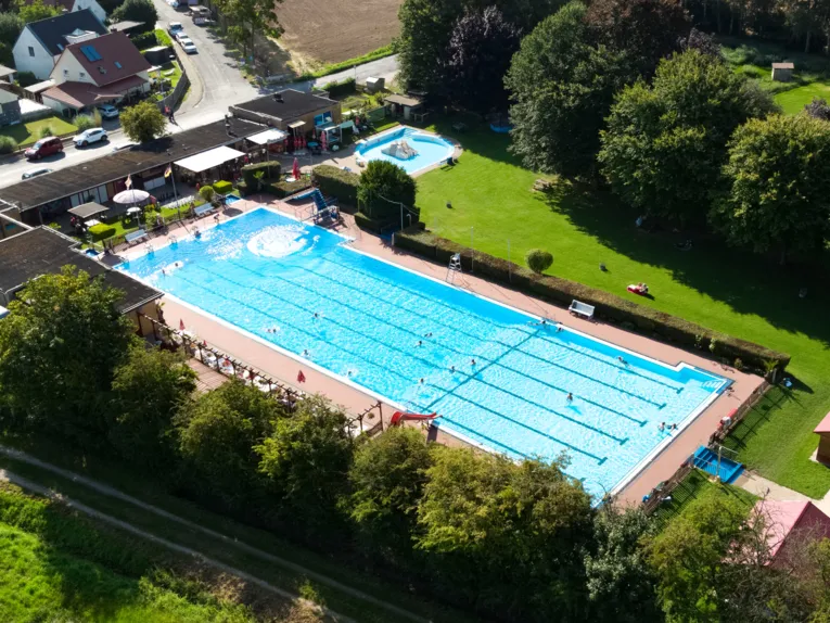 Luftbild vom Freibad mit Schwimmbecken, Kleinkindbecken, Geb&auml;uden und Liegewiese