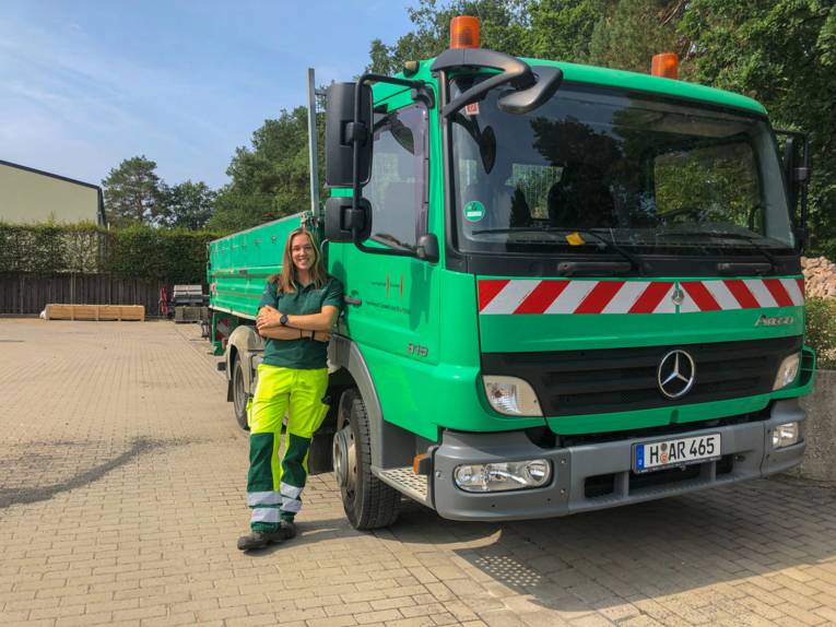 Person, die an einem Fahrzeug der Landeshauptstadt Hannover lehnt.