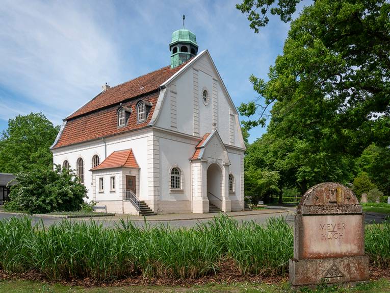 Ein Gebäude in einer grünen Friedhofsanlage.