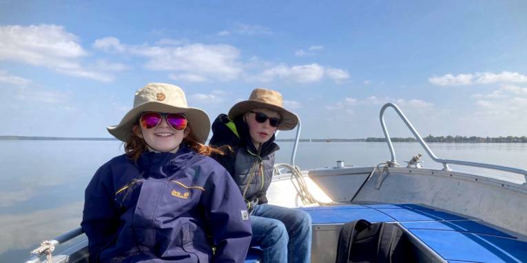 Zwei Kinder sitzen in einem Boot.