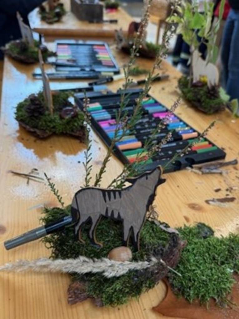 Eine Person h&auml;lt einen gebastelten Wolf vor der Brust.