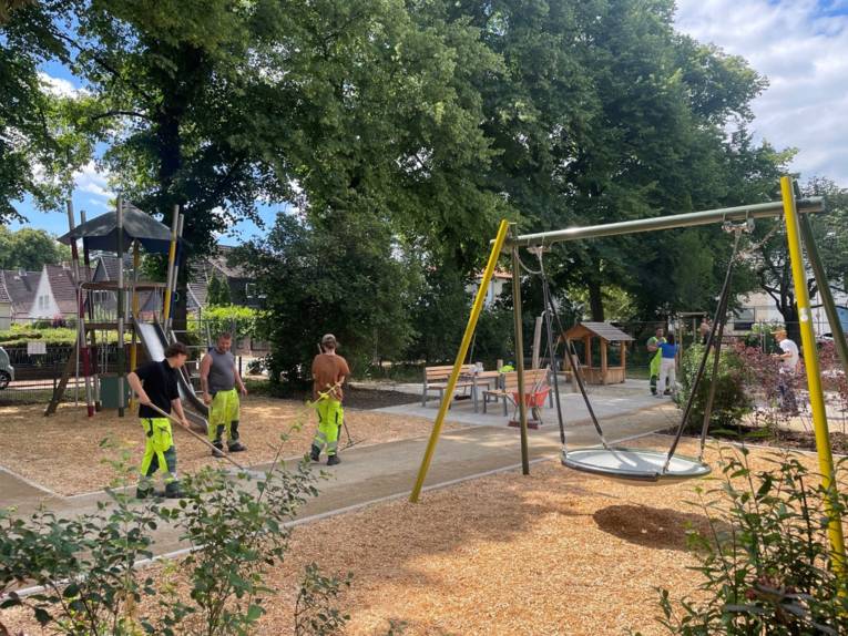 Personen auf einem Spielplatz, die letzte Arbeiten ausführen.