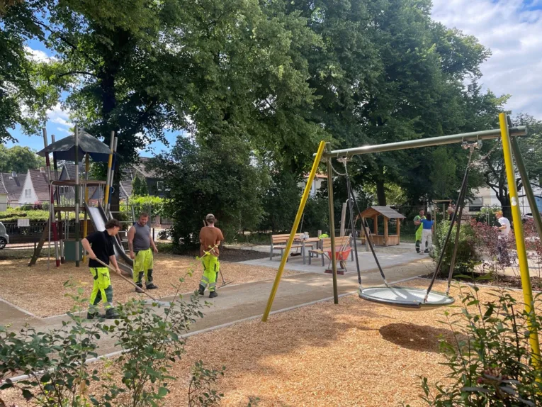 Personen auf einem Spielplatz, die letzte Arbeiten ausführen.