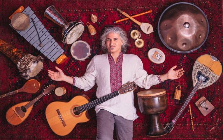 Zu sehen ist ein Mann, der auf dem Boden liegt. er ist umringt von verschiedenen Musikinstrumenten.