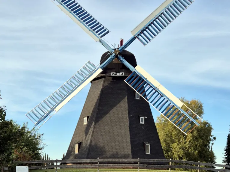 Auf einem Hügel steht eine Bockwindmühle