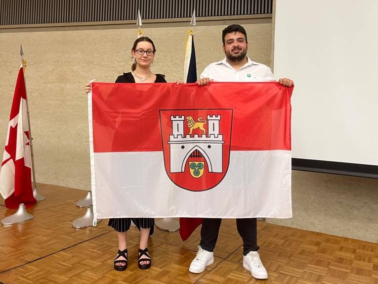 Zwei Personen mit einer Hannover-Flagge.