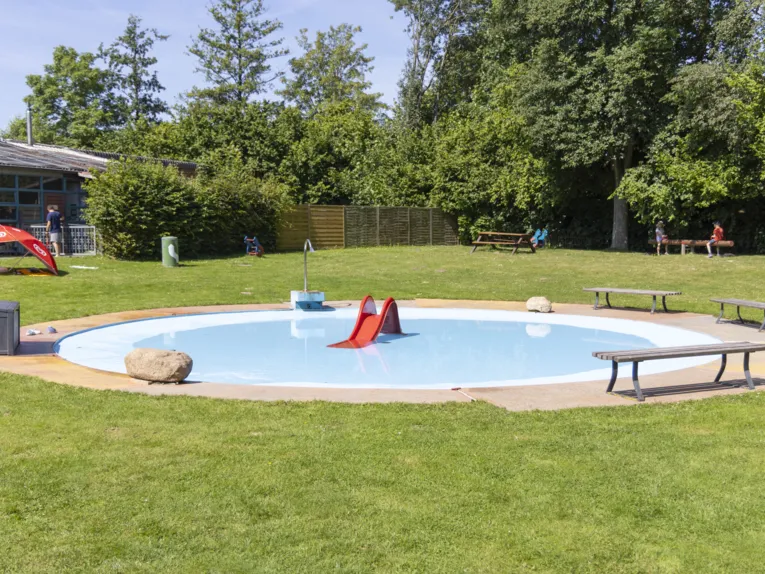 Freibad Goltern - Kinderplanschbecken mit Rutsche und B&auml;nken, die um das flache Becken stehen
