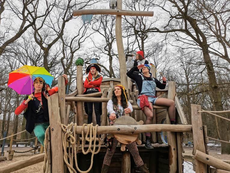Fünf Schauspielerinnen in Piratenkostümen auf einem Holzboot im Spielplatz Wakitu.
