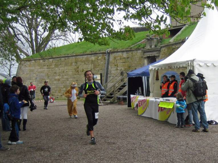 Marathonläufer vor einer Festungsanlage.