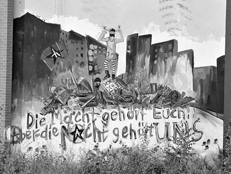 Gelände der Sprengel-Schokoladenfabrik, Hannover-Nordstadt, Schaufelderstraße. Foto von Gerhard Stoletzki, 09.08.1988
Entwicklung nach Krawallen und Hausbesetzungen zu einem alternativen Viertel. Graffiti „Die Macht gehört Euch! Aber die Nacht gehört UNS“.