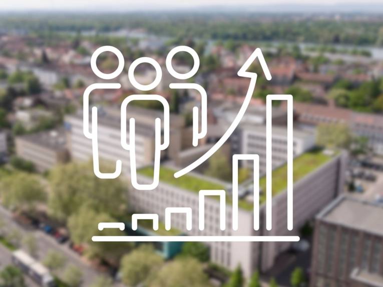 Luftaufnahme von urbaner Gebäude, am Horizont grüne Wälder. Im Vordergrund eine Grafik mit Menschen und einem aufsteigenden Diagramm.