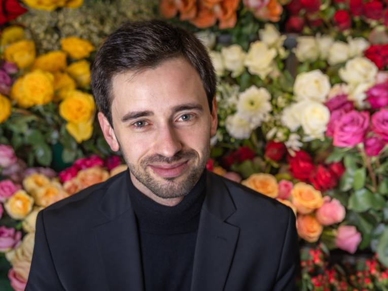 Mann mit Blumen im Hintergrund