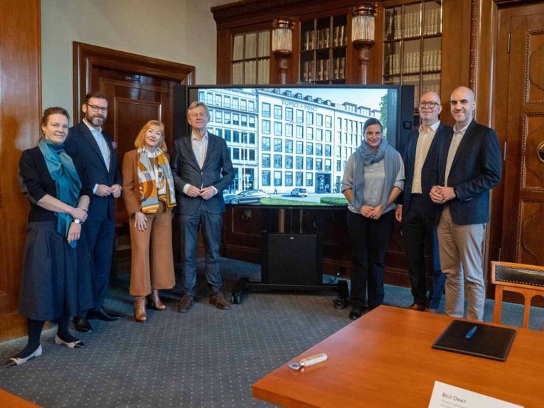 Menschengruppe vor großem Bildschirm