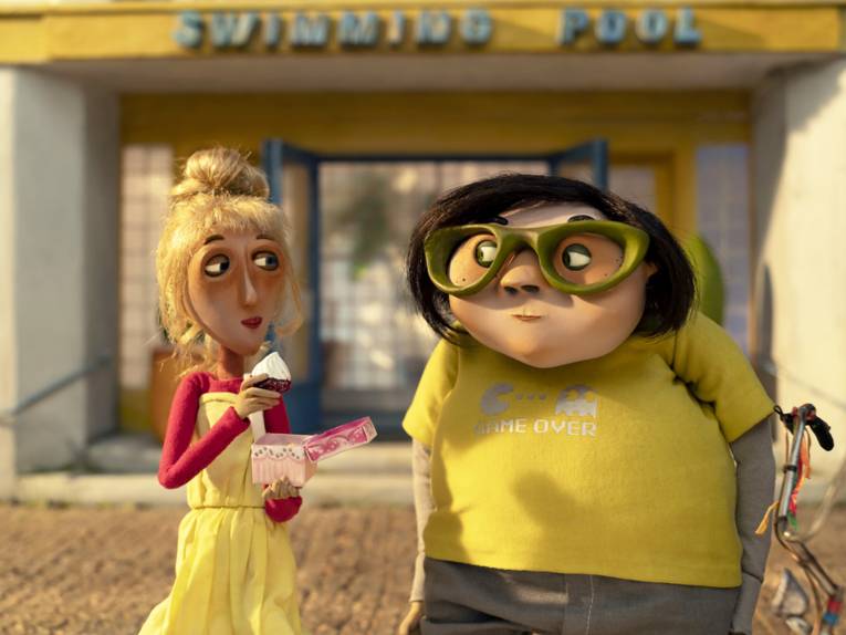 Knet-Figuren: eine dünne Frau und ein dicker Mann stehen vor einem Geschäft