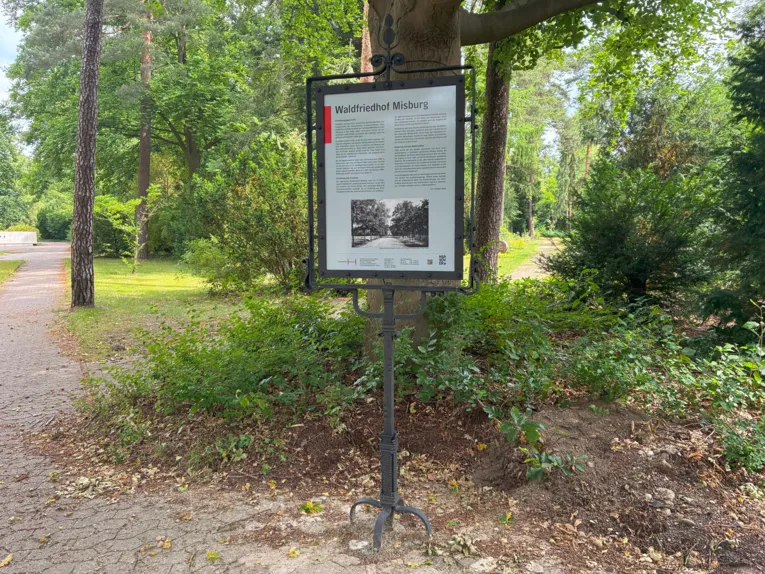 Ein Schild mit Informationen zu einem Friedhof.
